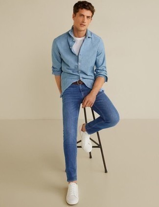 Как носить синие джинсы с бело-темно-синими низкими кедами из плотной ткани мужчине в теплую погоду: Голубая рубашка с длинным рукавом и синие джинсы — must have составляющие в гардеробе джентльменов с чувством стиля. Вместе с этим образом выигрышно смотрятся бело-темно-синие низкие кеды из плотной ткани.
