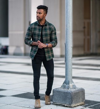 С чем носить черные зауженные джинсы мужчине в теплую погоду в стиле кэжуал: Темно-зеленая рубашка с длинным рукавом в шотландскую клетку и черные зауженные джинсы — великолепный образ для молодых людей, которые постоянно в движении. В тандеме с коричневыми замшевыми ботинками челси такой лук выглядит особенно гармонично.
