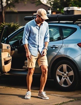 Модный мужской лук: голубая рубашка с длинным рукавом в мелкую клетку, светло-коричневые шорты, бежевые низкие кеды из плотной ткани, бежевая бейсболка