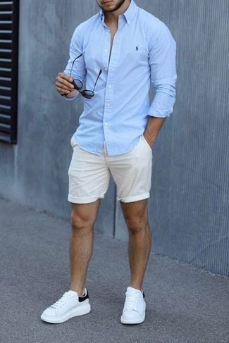 С чем носить серебряные солнцезащитные очки в 30 лет мужчине: Если в одежде ты ценишь удобство и практичность, голубая рубашка с длинным рукавом и серебряные солнцезащитные очки — превосходный вариант для привлекательного повседневного мужского лука. Хотел бы сделать лук немного элегантнее? Тогда в качестве обуви к этому луку, выбери белые кожаные низкие кеды.