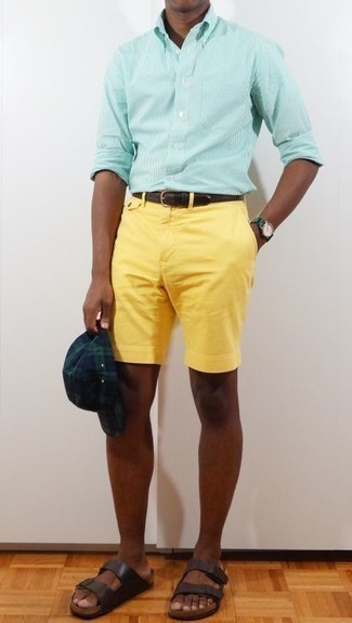 С чем носить желтые шорты мужчине в теплую погоду в спортивном стиле: Тандем мятной рубашки с длинным рукавом в вертикальную полоску и желтых шорт поможет создать незаезженный мужской лук в стиле кэжуал. Дополнив образ темно-коричневыми кожаными сандалиями, можно привнести в него немного беззаботства.