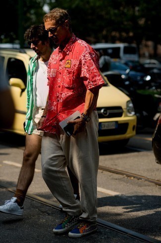 Какие брюки чинос носить с разноцветными высокими кедами в стиле кэжуал: Комбо из красной рубашки с коротким рукавом с "огурцами" и брюк чинос безусловно будет обращать на себя взгляды красивых дам. Любишь дерзкие сочетания? Закончи свой образ разноцветными высокими кедами.