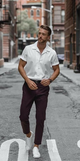 С чем носить пурпурные брюки чинос: Белая рубашка с коротким рукавом в паре с пурпурными брюками чинос — великолепная идея для создания мужского ансамбля в стиле смарт-кэжуал. Белые кожаные низкие кеды прекрасно дополнят этот образ.