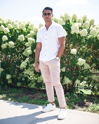 Модный лук: белая рубашка с коротким рукавом, розовые брюки чинос, белые низкие кеды из плотной ткани, темно-коричневые солнцезащитные очки