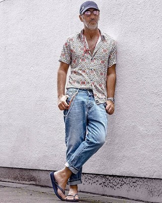 С чем носить рваные джинсы за 50 лет мужчине лето в спортивном стиле: Если ты ценишь комфорт и практичность, разноцветная рубашка с коротким рукавом с принтом и рваные джинсы — отличный вариант для привлекательного повседневного мужского образа. Тебе нравятся незаурядные решения? Можешь закончить свой лук темно-синими сланцами. Не стоит забывать о таком образе, особенно когда за окном 25 градусов жары, а то и больше.