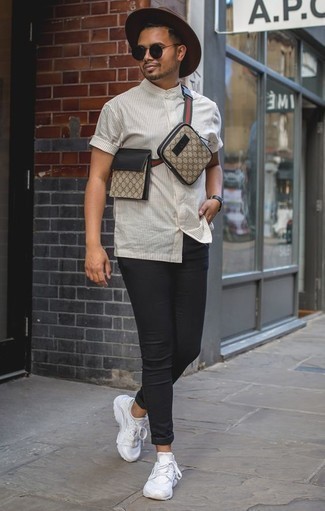Модный лук: белая рубашка с коротким рукавом в вертикальную полоску, черные зауженные джинсы, белые кроссовки, бежевая поясная сумка из плотной ткани