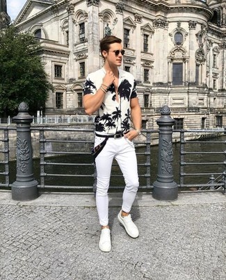 С чем носить белые джинсы в 20 лет мужчине в стиле кэжуал: Бело-черная рубашка с коротким рукавом с цветочным принтом и белые джинсы — хороший выбор для веселого выходного дня. Пара белых кожаных низких кед легко интегрируется в этот образ.