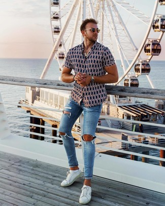 Как носить темно-синие рваные джинсы с белыми кожаными низкими кедами в 20 лет мужчине лето в спортивном стиле: Если ты ценишь комфорт и практичность, темно-синяя рубашка с коротким рукавом с принтом и темно-синие рваные джинсы — замечательный выбор для модного мужского ансамбля на каждый день. Думаешь добавить в этот лук нотку строгости? Тогда в качестве обуви к этому ансамблю, выбери белые кожаные низкие кеды. Разумеется, подобный лук станет хорошей идеей в теплый летний день.
