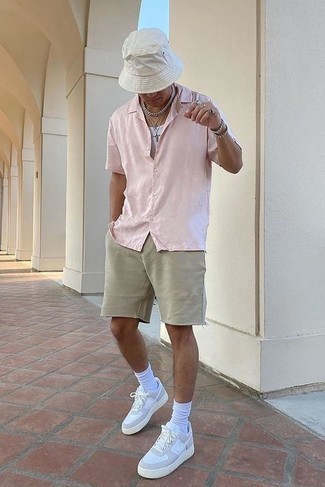 С чем носить бежевые шорты в 20 лет мужчине в спортивном стиле: Если ты наметил себе суматошный день, сочетание розовой рубашки с коротким рукавом и бежевых шорт позволит создать удобный лук в стиле кэжуал. Вкупе с этим луком органично будут выглядеть белые кожаные низкие кеды.