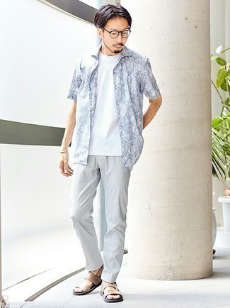 Модный лук: бело-синяя рубашка с коротким рукавом с принтом, белая футболка с круглым вырезом, серые брюки чинос, светло-коричневые кожаные сандалии