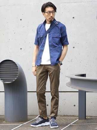 С чем носить коричневые брюки чинос в 30 лет лето в стиле кэжуал: Синяя рубашка с коротким рукавом и коричневые брюки чинос — отличная идея для простого, но модного мужского лука. Ты можешь легко приспособить такой образ к повседневным реалиям, надев темно-сине-белыми кроссовками. Подобный образ несомненно придется тебе по душе в знойные летние дни.
