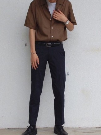 Модный лук: коричневая рубашка с коротким рукавом, белая футболка с круглым вырезом, темно-синие брюки чинос, черные кожаные туфли дерби