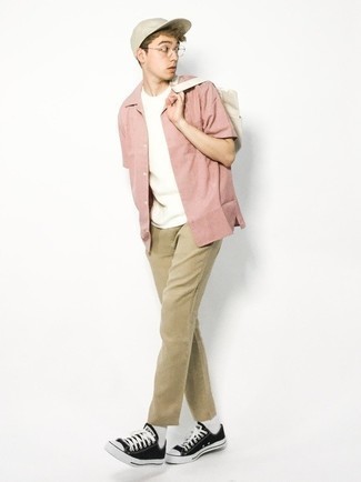 Модный лук: розовая рубашка с коротким рукавом, белая футболка с круглым вырезом, светло-коричневые брюки чинос, черно-белые низкие кеды из плотной ткани