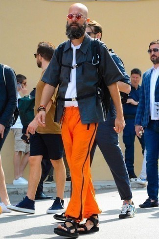 С чем носить оранжевые брюки за 50 лет мужчине лето: Темно-синяя рубашка с коротким рукавом и оранжевые брюки — беспроигрышный образ для веселого выходного дня. Тебе нравятся дерзкие решения? Дополни свой ансамбль черными сандалиями из плотной ткани. Подобный лук обязательно придется тебе по душе в жаркие солнечные деньки.