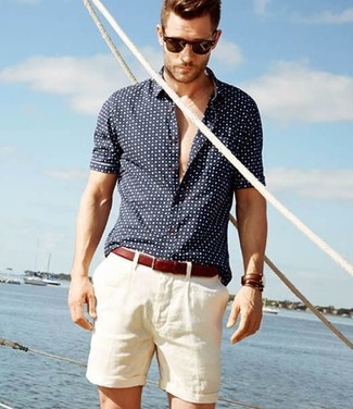 Модный лук: темно-сине-белая рубашка с коротким рукавом в горошек, белые шорты, темно-красный кожаный ремень, темно-коричневые солнцезащитные очки