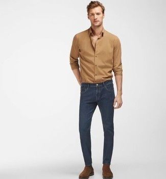 Как носить темно-синие джинсы с бежевой рубашкой с длинным рукавом мужчине: Дуэт бежевой рубашки с длинным рукавом и темно-синих джинсов позволит выглядеть по моде, а также выразить твою индивидуальность. Хочешь привнести сюда толику классики? Тогда в качестве обуви к этому ансамблю, стоит обратить внимание на коричневые замшевые ботинки челси.
