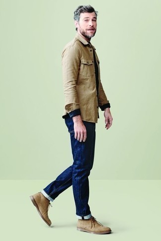 Как носить темно-синие джинсы с светло-коричневыми замшевыми ботинками дезертами за 40 лет в теплую погоду: Светло-коричневая рубашка с длинным рукавом и темно-синие джинсы надежно закрепились в гардеробе современных молодых людей, позволяя составлять выразительные и стильные образы. Светло-коричневые замшевые ботинки дезерты — прекрасный выбор, чтобы дополнить образ.