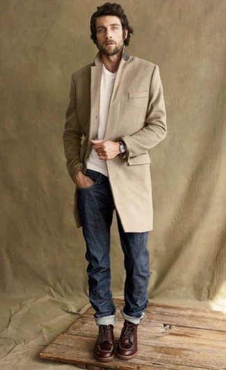 С чем носить табачные рабочие ботинки в 30 лет мужчине в прохладную погоду: Светло-коричневое длинное пальто в паре с темно-синими джинсами — прекрасный офисный вариант для парней. Если сочетание несочетаемого привлекает тебя не меньше, чем безвременная классика, закончи этот образ табачными рабочими ботинками.