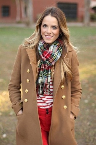 Модный лук: светло-коричневое пальто, бело-красный свитер с круглым вырезом в горизонтальную полоску, красные джинсы скинни, зеленый шарф в шотландскую клетку