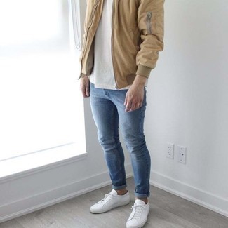 Модный лук: светло-коричневый бомбер, белая футболка с круглым вырезом, синие зауженные джинсы, белые низкие кеды из плотной ткани