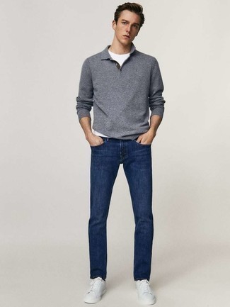 Как носить темно-синие джинсы с белыми низкими кедами из плотной ткани мужчине: Если ты принадлежишь к той немногочисленной категории молодых людей, способных неплохо ориентироваться в одежде, тебе придется по душе лук из серого свитера с воротником поло и темно-синих джинсов. Создать запоминающийся контраст с остальными вещами из этого образа помогут белые низкие кеды из плотной ткани.