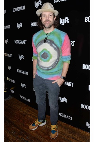 Как Jason Sudeikis носит Разноцветный свитер с круглым вырезом c принтом тай-дай, Темно-серые брюки чинос, Разноцветные кроссовки, Бежевая шерстяная шляпа