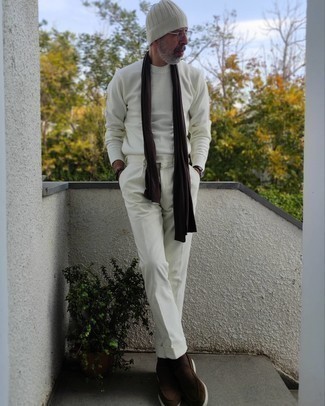 С чем носить белые брюки чинос за 50 лет: Белый свитер с круглым вырезом и белые брюки чинос — хороший выбор, если ты ищешь раскованный, но в то же время модный мужской ансамбль. Такой ансамбль обретает свежее прочтение в сочетании с темно-коричневыми замшевыми лоферами.