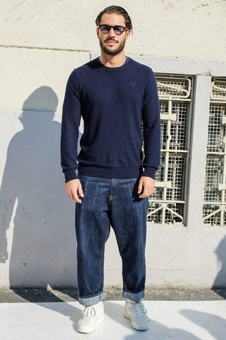 Модный лук: темно-синий свитер с круглым вырезом, темно-синие джинсы, белые кожаные низкие кеды, голубые солнцезащитные очки