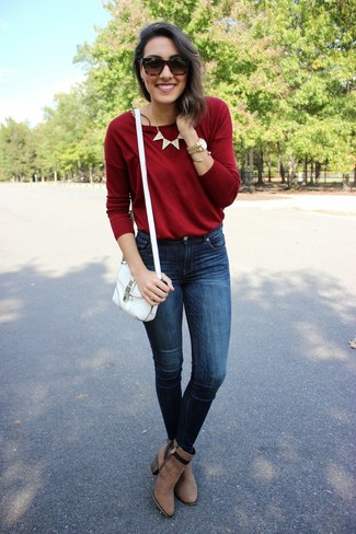 Модный лук: красный свитер с круглым вырезом, темно-синие джинсы скинни, коричневые замшевые ботильоны, белая сумка через плечо