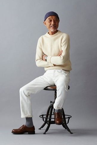 С чем носить джинсы за 50 лет мужчине в стиле смарт-кэжуал: Окружающие оценят твой стиль, когда увидят тебя в бежевом свитере с круглым вырезом и джинсах. Такой образ получает новое прочтение в паре с коричневыми кожаными туфлями дерби.