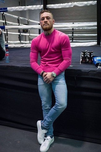 Как Conor McGregor носит Ярко-розовый свитер с круглым вырезом, Голубые зауженные джинсы, Белые кожаные низкие кеды, Золотые часы