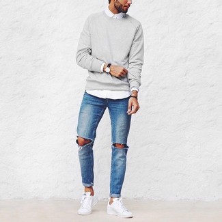 Модный лук: серый свитер с круглым вырезом, белая рубашка с длинным рукавом, синие рваные джинсы, белые низкие кеды