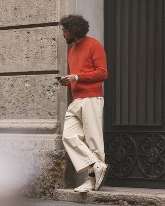 Какие брюки чинос носить с бежевыми высокими кедами: Образ из красного свитера с круглым вырезом и брюк чинос позволит выглядеть стильно, но при этом выразить твой индивидуальный стиль. Создать запоминающийся контраст с остальными вещами из этого образа помогут бежевые высокие кеды.