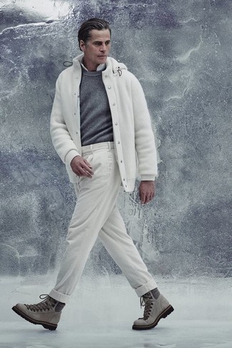 Как одеваться мужчине за 40: Если в одежде ты ценишь комфорт и функциональность, тебе понравится это тандем серого свитера с круглым вырезом и белых брюк чинос. Любишь смелые решения? Тогда заверши свой ансамбль серыми замшевыми рабочими ботинками.