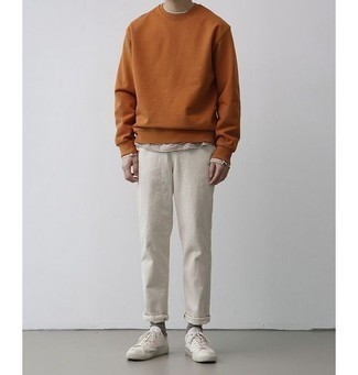 С чем носить оранжевый свитшот мужчине: Оранжевый свитшот в сочетании с белыми брюками чинос подчеркнет твою индивидуальность. В тандеме с этим ансамблем наиболее выигрышно будут выглядеть белые низкие кеды из плотной ткани.