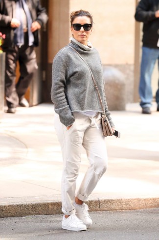 Как одеваться женщине за 40: Образ из серого свитшота и белых брюк чинос - самый простой из возможных образов для активного досуга. Белые кожаные низкие кеды становятся великолепным дополнением к твоему образу.