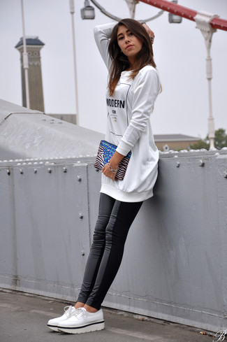 Модный лук: бело-черный свободный свитер с принтом, черные кожаные леггинсы, белые кожаные оксфорды, бело-черный замшевый клатч в горизонтальную полоску