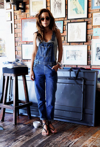 С чем носить синие джинсовые комбинезон в 30 лет: Если ты делаешь ставку на комфорт и функциональность, серая майка и синие джинсовые штаны-комбинезон — классный вариант для привлекательного повседневного наряда. Черные кожаные вьетнамки — идеальный выбор, чтобы закончить лук.