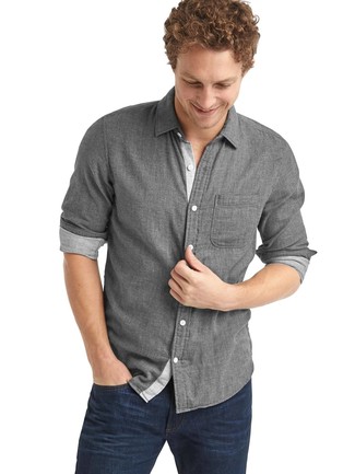 Как носить серую рубашку с длинным рукавом с темно-синими джинсами в 20 лет мужчине в теплую погоду в стиле кэжуал: Ансамбль из серой рубашки с длинным рукавом и темно-синих джинсов поможет создать необычный мужской лук в непринужденном стиле.