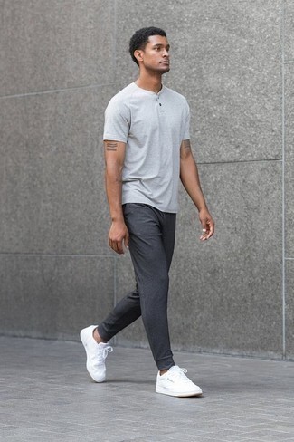 Модный лук: серая футболка на пуговицах, темно-серые спортивные штаны, белые низкие кеды из плотной ткани