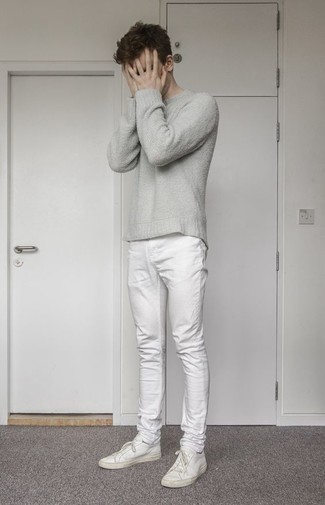 С чем носить бело-черные джинсы в 20 лет мужчине в жару: Серая футболка с круглым вырезом и бело-черные джинсы надежно обосновались в гардеробе многих молодых людей, помогая создавать неприевшиеся и стильные образы. Вместе с этим луком великолепно выглядят белые кожаные низкие кеды.