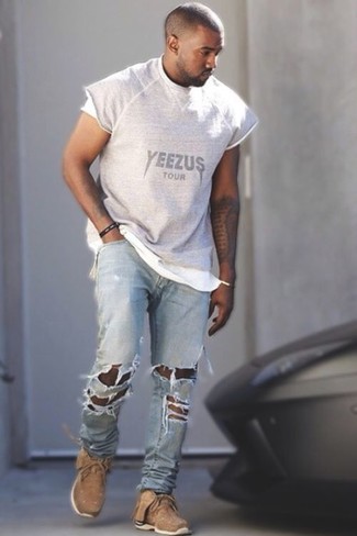 Как Kanye West носит Серая футболка с круглым вырезом с принтом, Голубые рваные джинсы, Светло-коричневые кроссовки