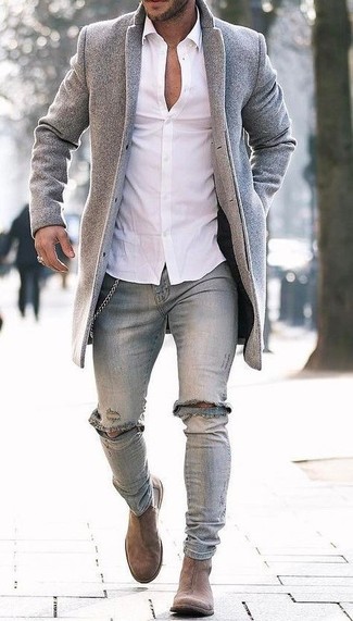 С чем носить темно-серые рваные джинсы в 30 лет мужчине в холод в стиле смарт-кэжуал: Серое длинное пальто в паре с темно-серыми рваными джинсами — хороший вариант для создания мужского образа в стиле smart casual. Этот лук обретет новое прочтение в тандеме с светло-коричневыми замшевыми ботинками челси.