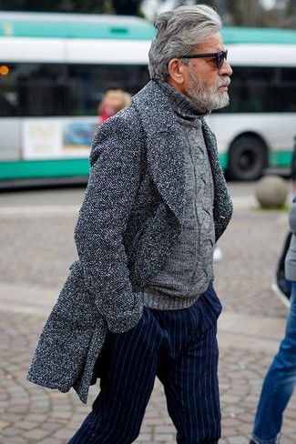 С чем носить серый свитер за 60 лет мужчине в холод в стиле смарт-кэжуал: Серый свитер и темно-синие классические брюки в вертикальную полоску — отличный вариант для воплощения мужского лука в стиле элегантной повседневности.