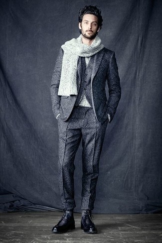 С чем носить серый шерстяной костюм в прохладную погоду: Сочетание серого шерстяного костюма и серого свитера с круглым вырезом — олицетворение изысканного мужского стиля. Что касается обуви, можно отдать предпочтение комфорту и надеть черные кожаные повседневные ботинки.