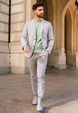 С чем носить серый пиджак мужчине: Фанатам стиля smart casual полюбится лук из серого пиджака и бежевых брюк чинос. Любишь экспериментировать? Дополни лук бежевыми замшевыми ботинками челси.