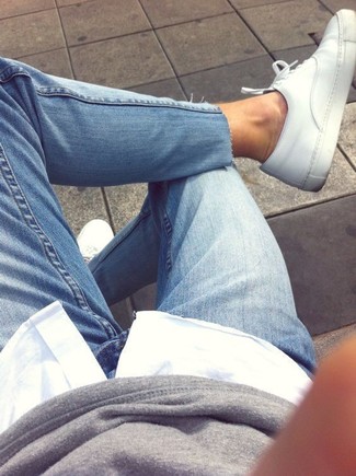 Как носить серый свитшот с синими джинсами женщине в теплую погоду в стиле смарт-кэжуал: Сочетание серого свитшота и синих джинсов позволит выразить твой выразительный стиль. В тандеме с белыми кожаными низкими кедами весь лук выглядит очень занятно.