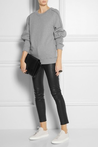 Модный лук: серый свободный свитер, черные кожаные узкие брюки, белые кожаные низкие кеды, черный кожаный клатч