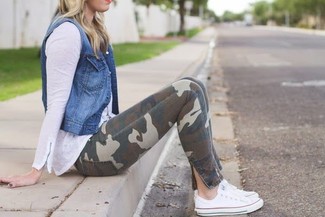 С чем носить коричневые джинсы скинни с камуфляжным принтом в теплую погоду: Тандем синей джинсовой безрукавки и коричневых джинсов скинни с камуфляжным принтом вдохновляет на проявление личного стиля. Пара белых низких кед свяжет лук воедино.
