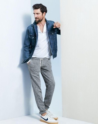 С чем носить серые спортивные штаны мужчине: Синяя джинсовая куртка и серые спортивные штаны будет классной идеей для легкого повседневного образа. Что же до обуви, белые низкие кеды — самый достойный вариант.